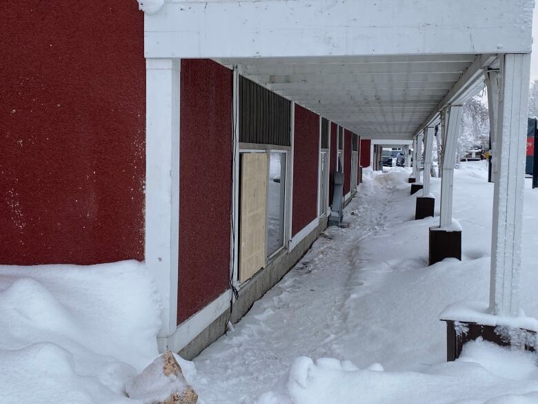 The outside of a building with boarded up windows.