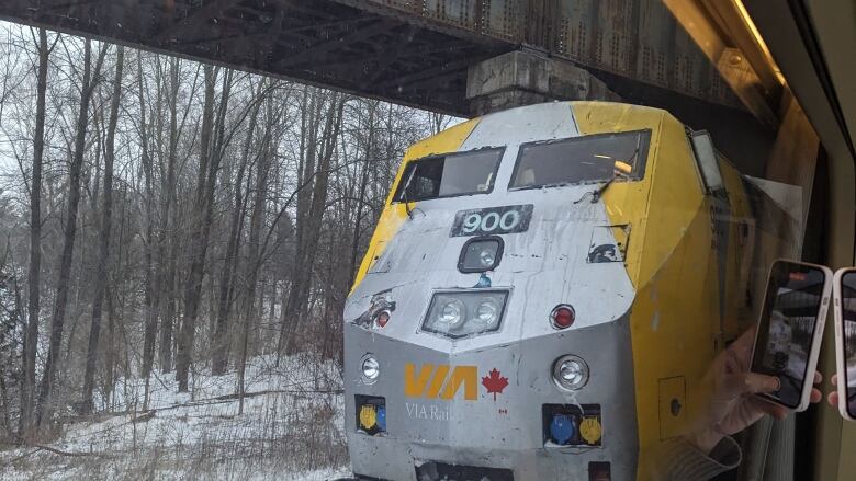 A Via Rail train is seen from the carriage of another train.