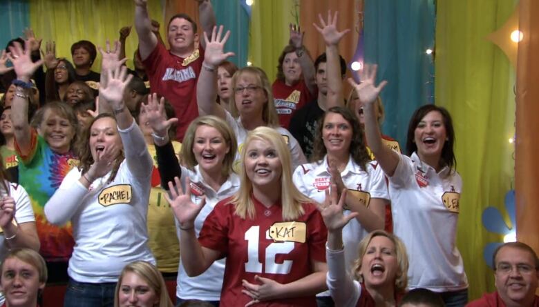 Members of the audience at The Price is Right wace their hands in the air.