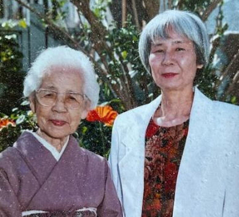 An elderly woman in a kimono stands next to a middle-aged woman in a sport coat.