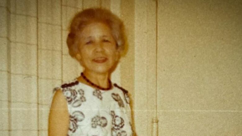 A middle-aged woman smiles for a photo taken many decades ago.