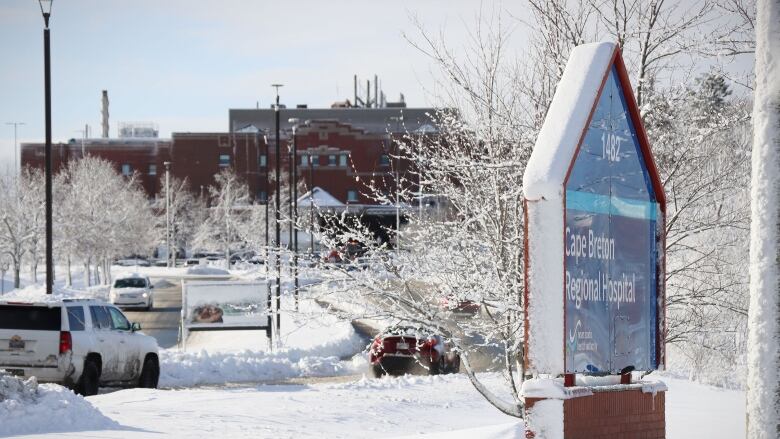 A sign indicates the Cape Breton Regional Hospital and looks down a long road to the hospital building.