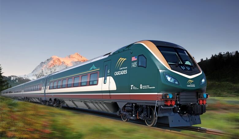 A green-coloured train, with coffee-coloured accents, speeds along a track with a mountain in the background.