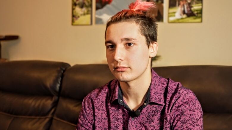 Trofim Modlyi sits on a couch in Grande Prairie, Alberta.