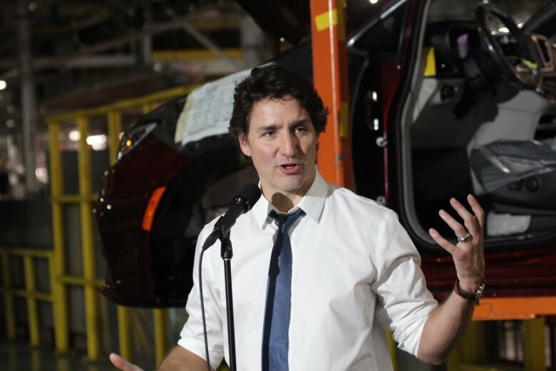 Justin Trudeau speaks with minivan assembly in the background