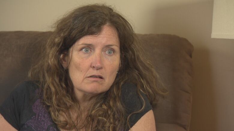 A portrait of a woman with long curly hair looking off camera.