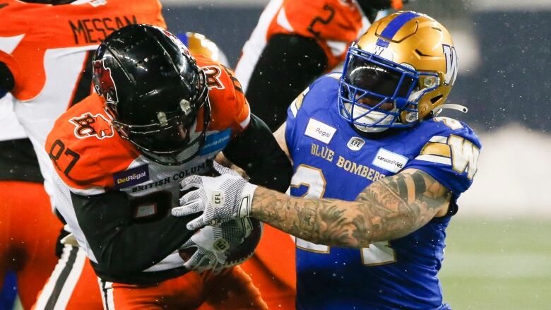 Winnipeg Blue Bombers' Mike Miller (24) tackles BC Lions' Terry Williams (87) during the second half of CFL western final action in Winnipeg, Sunday, Nov. 13, 2022. 