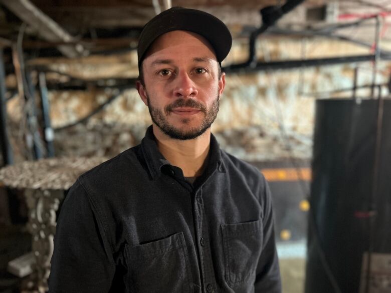 A man stands in a basement. 