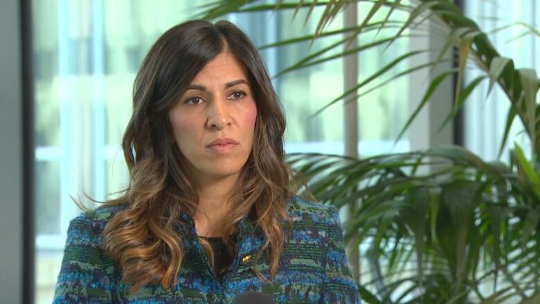 A woman sits down facing the camera for an interview.