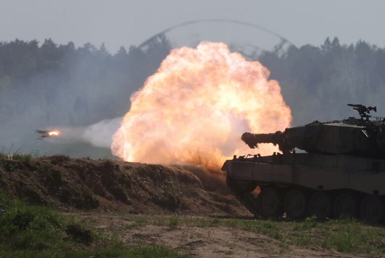 A ball of fire is seen near a tank, with a projectile also shown.