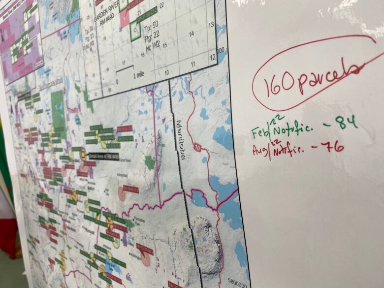 A map of Saskatchewan has various labels coloured green and red, pinpointing plots of land that will be up for auction. Next to the map, some had written and circled, '160 parcels,' then broke down how many are being sold and when. 