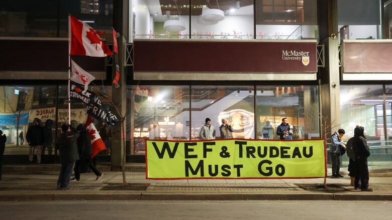 Protesters in Hamilton display a banner that says 