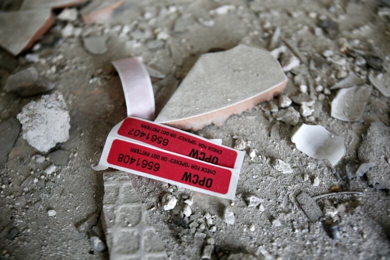 A closeup with rubble and a red tag is shown.