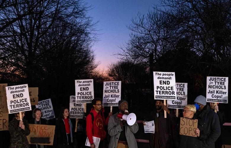 Protesters hold signs during a rally.