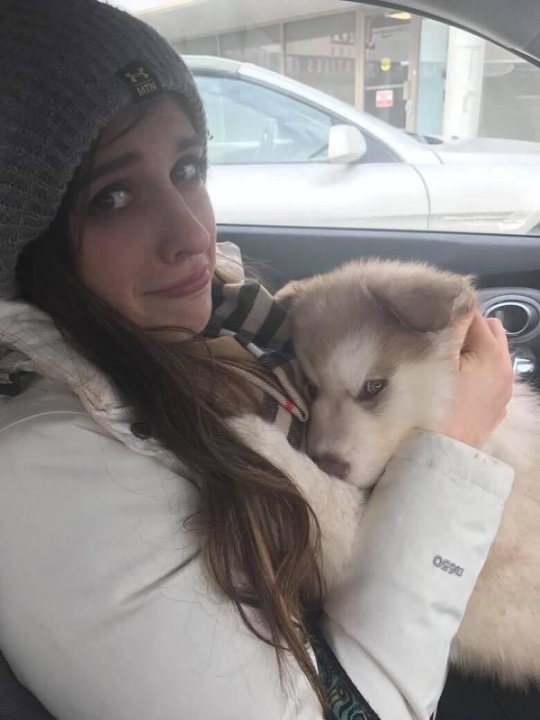 A woman in a car with an Alaskan malamute