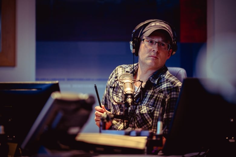 Adam Walsh wearing headphones in studio at CBC. 