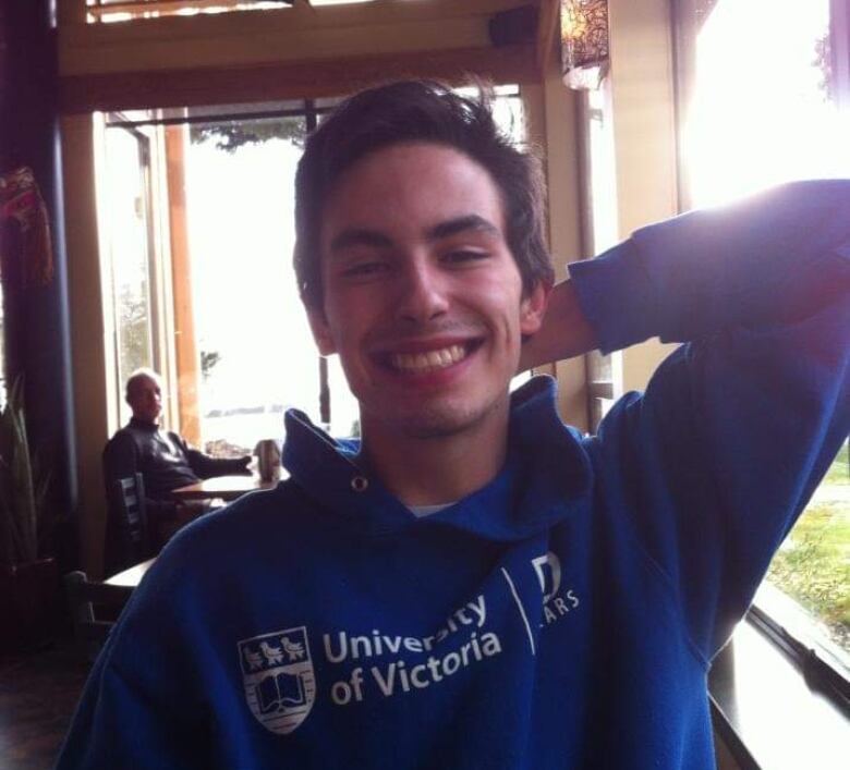 Smiling man in University of Victoria hoodie.