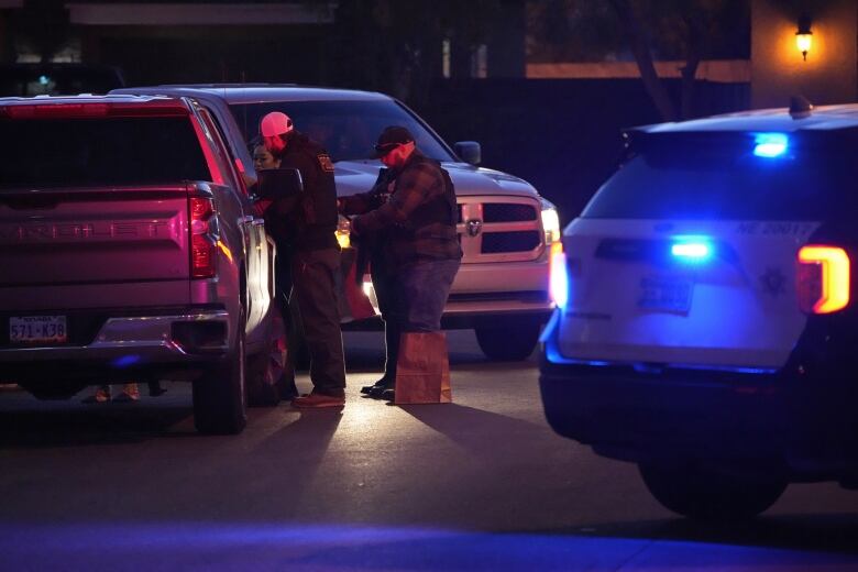 Police officers congregate beside a pickup in North Las Vegas.