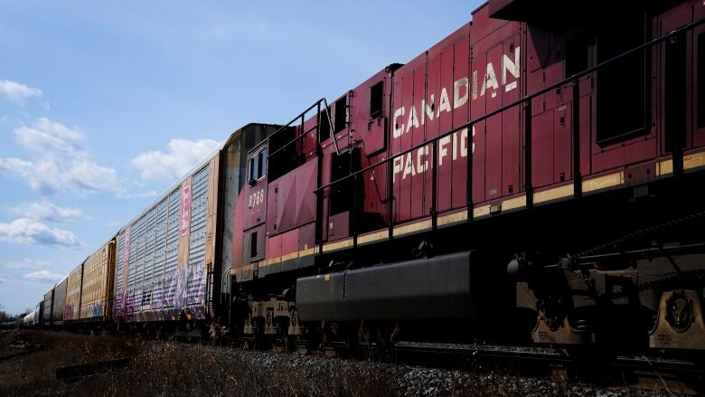 CP trains sit on a track at the main trainyard in Toronto, with blue sky in the background.