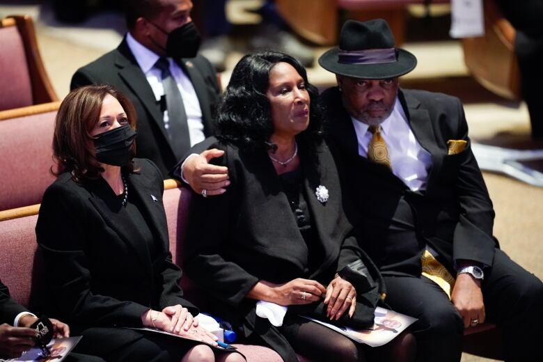 U.S. Vice-President Kamala Harris sits with a couple during a funeral for the woman's Black son.