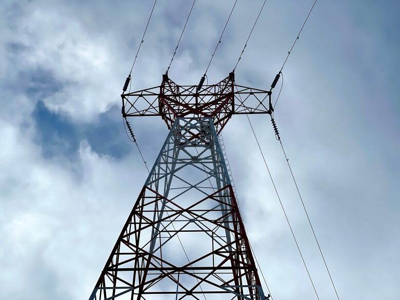 A power pole is shown against a cloudy sky