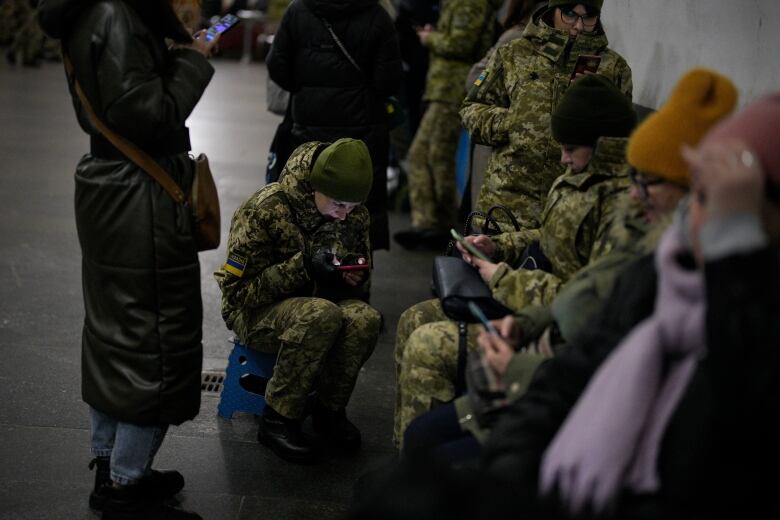 People huddle in a subway station.