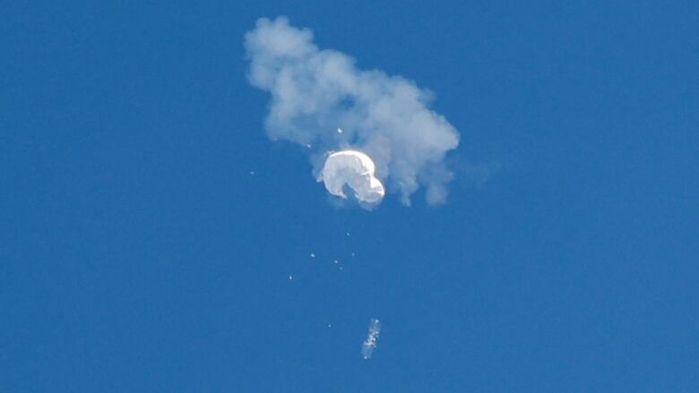 An object, suspected to be a spy balloon, is seen in the sky.