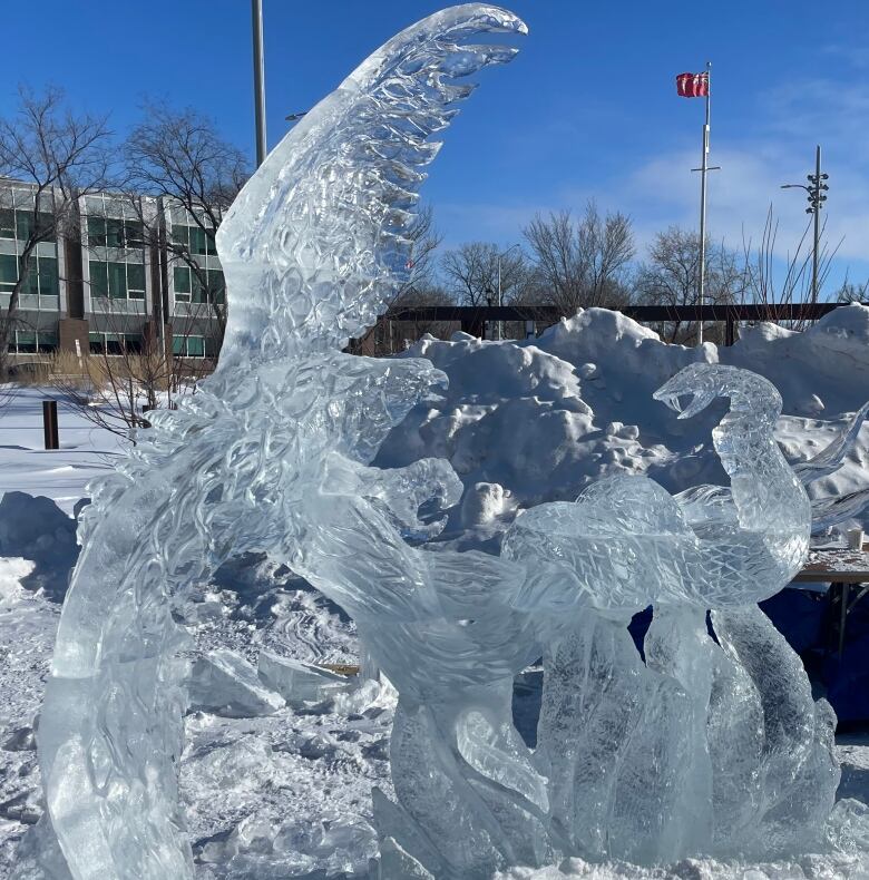 An ice sculpture is pictured of a snake and phoenix in battle.