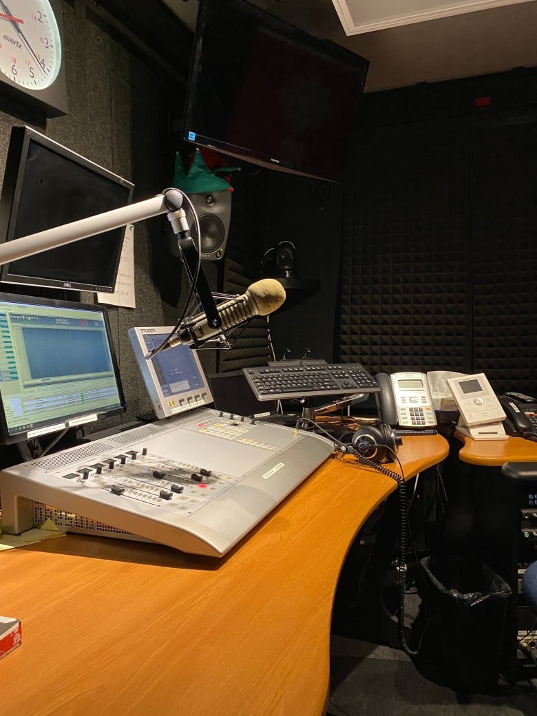 A view inside the radio studio. A microphone sits above a control board.