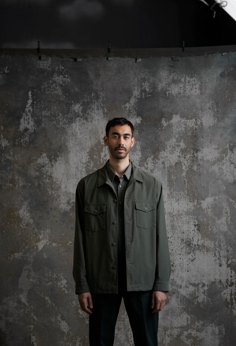 Antoine Bourges standing against a concrete-style backdrop.