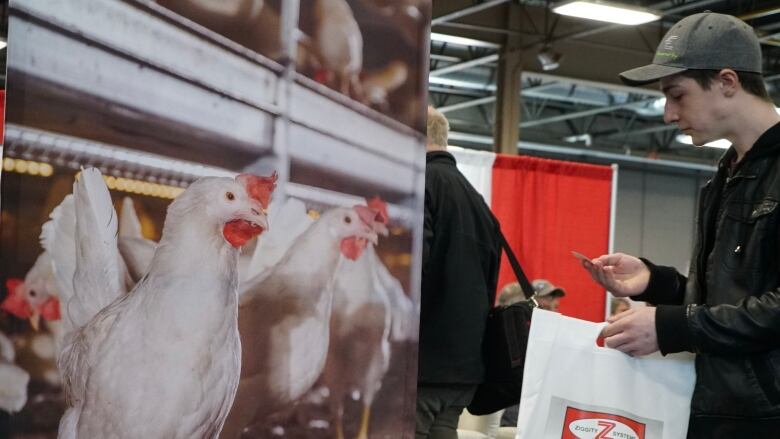 A man walking past a picture of a commercial chicken