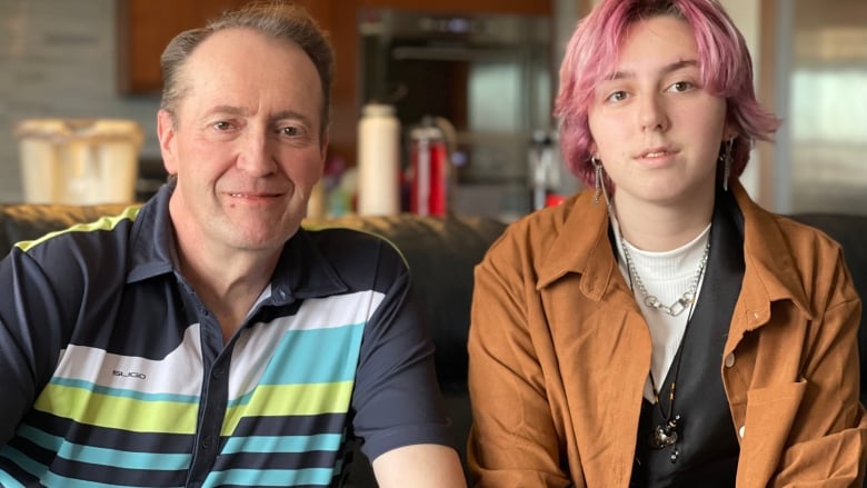 Charles Lee and his teen Kai sit together on a sofa in their northwest Calgary home.