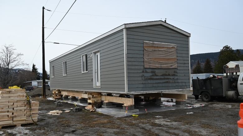 A modular home stands on an open ground.