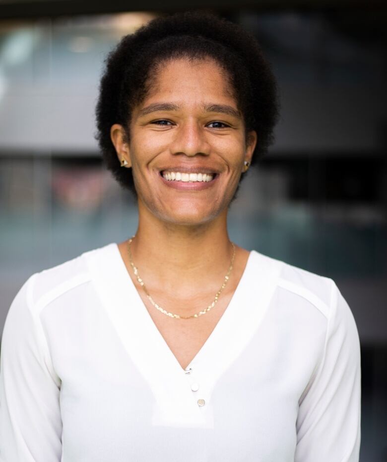 A woman in a white shirt smiles for the camera