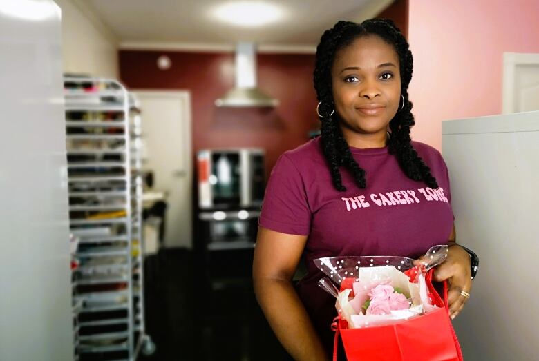 Opeyemi Bamigboye stands with a bag full of roses.