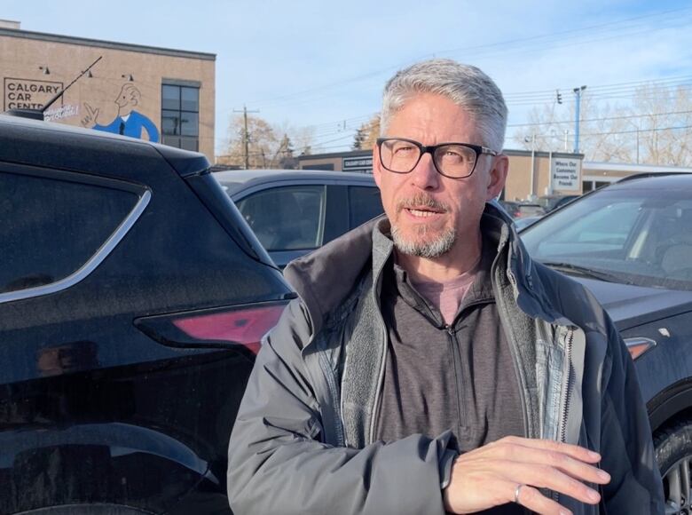 Bruce MacDonnell stands in front of a used car lot in Inglewood. The site was part of a proposal for a 12 storey mixed use development.