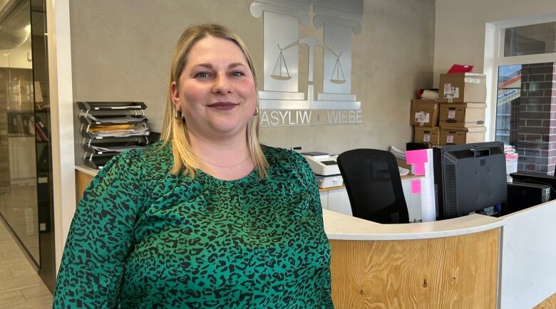 A woman stands in a Winnipeg law firm.