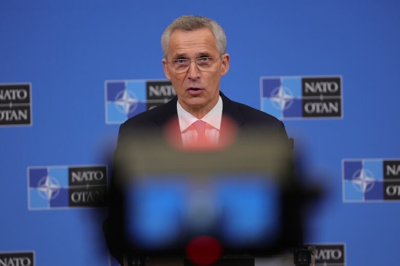 A man in a suit stands at a podium