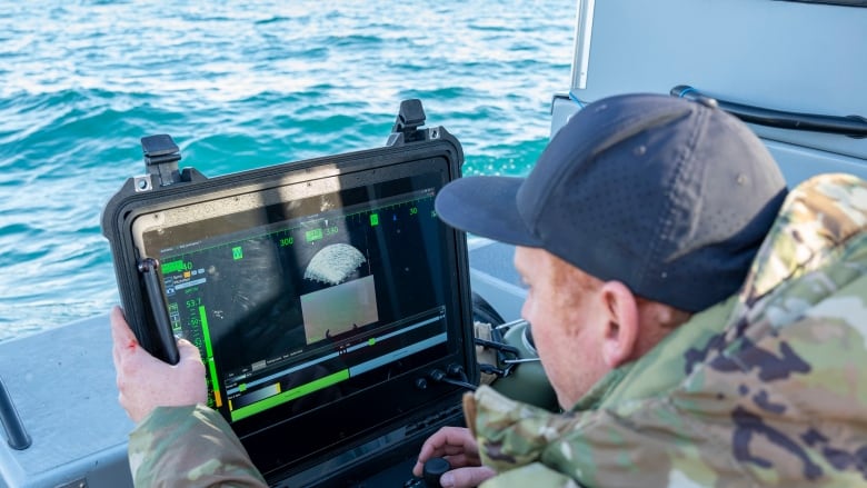 A sailor looks at monitoring equipment.