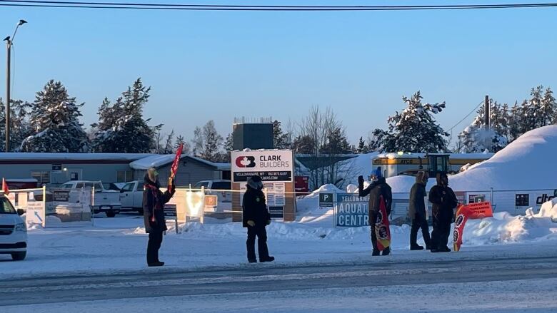 People in warm clothing, snow, construction site.