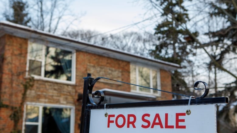 A for sale sign is pictured in front of a home.