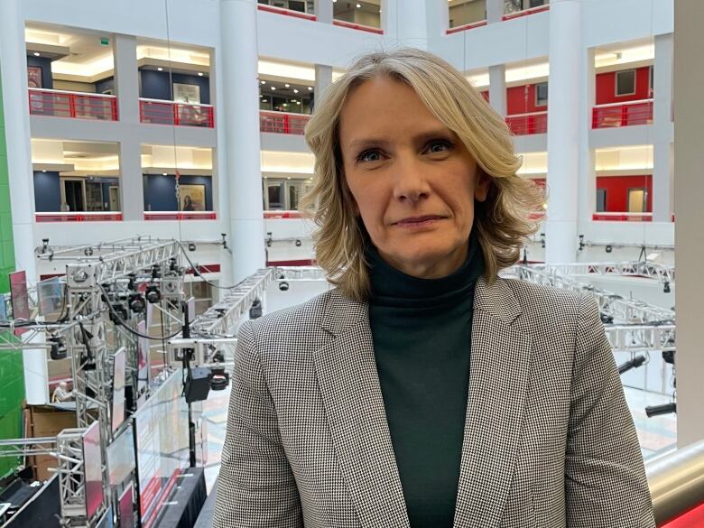 A woman smiling into the camera standing above the CBC Atrium.