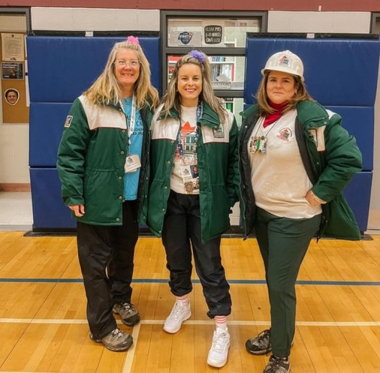 Three women wearing green and white jackets from the 1991 Canada Games. 