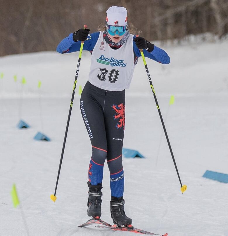 A woman cross-country skis on snow.