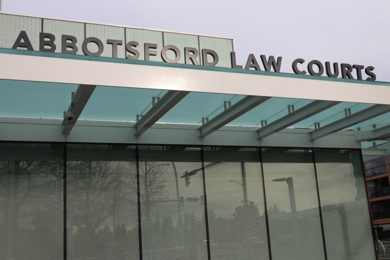 A simple text signage 'Abbotsford Law Courts' is installed in front of a building.