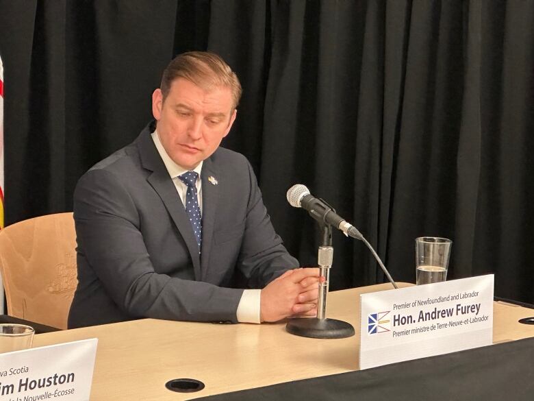 Premier Andrew Furey sitting at a desk looking to the side.