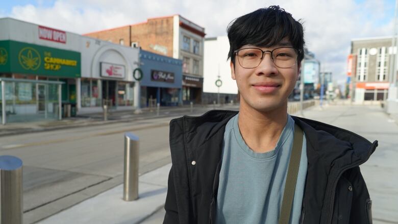 Kai Wong Nguyen is standing on the sidewalk in downtown Kitchener. 