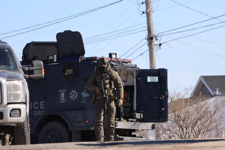 SWAT team member in front of a heavily armoured vehicle