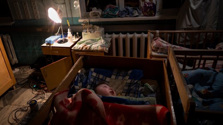 Orphaned children sleep inside cribs at the children's regional hospital maternity ward in Kherson, southern Ukraine.