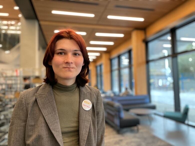 A young woman stands inside a university.